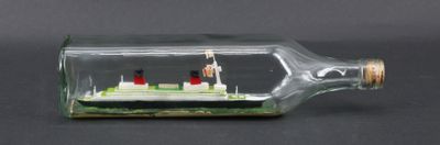 a small ship in a glass bottle on a table