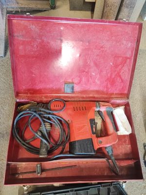 une boîte rouge posée par terre, contenant des outils