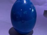 un vase bleu posé sur une table à côté d'un autre vase bleu
