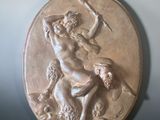 a bronze plaque of a man on a horse with a spear