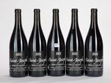 quatre bouteilles de vin sont alignées sur une surface blanche