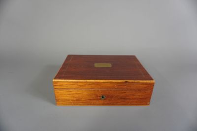 une vieille boîte en bois posée sur une surface blanche