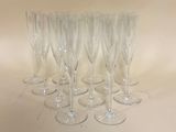 six verres à vin transparents sont alignés sur une surface blanche