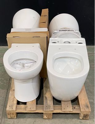 two toilets sitting on a pallet in a warehouse