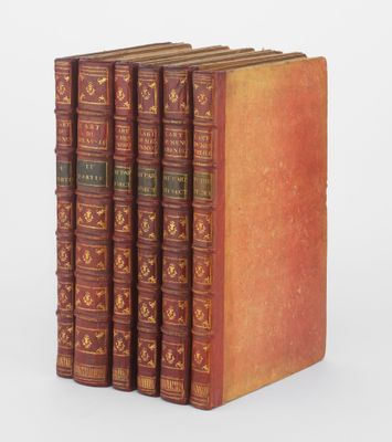 un lot de cinq livres anciens empilés les uns sur les autres