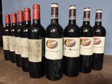 several bottles of wine are lined up on a wooden table
