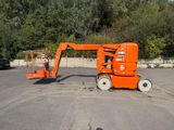une paire de ciseaux orange posée au milieu d'un parking