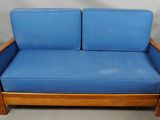 an image of a blue couch with a wooden frame and blue cushions