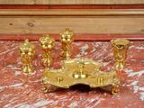 a gold candle holder with five candles on a marble table