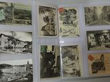 a person holding a pair of scissors in front of a bunch of old postcards