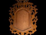 a wooden mirror hanging on the wall in the dark