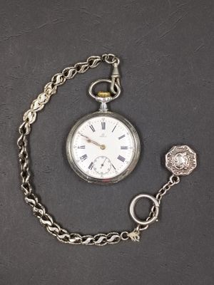 a silver pocket watch with a chain around it