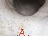 a close up of a white vase with a letter on it