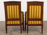 pair of antique chairs with striped upholstered back and arms