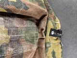 the back pocket of a camouflage backpack with a zipper on it