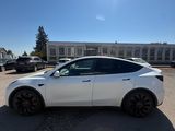 a white tesla suv parked in a parking lot in front of a building