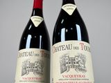two bottles of red wine sitting next to each other on a table