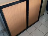 a wooden cabinet with two doors on the side of it