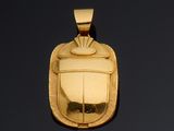 a close up of a gold pendant on a black background
