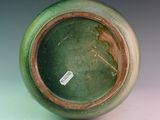 a close up of a green vase with a tag on it