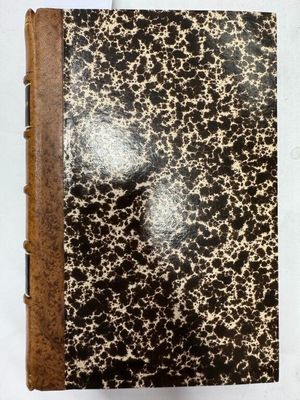 un vieux livre dont les pages, parsemées de taches noires et blanches, se détachent sur une couverture blanche