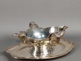 une assiette en argent ornée d'un oiseau en argent