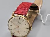 une montre montée sur un bracelet en cuir rouge