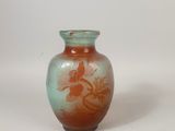 un petit vase posé sur une surface blanche
