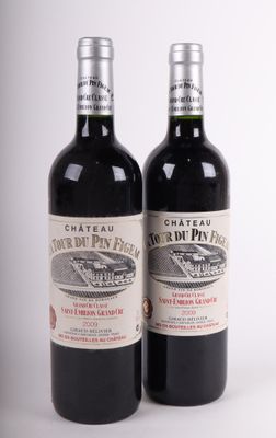 deux bouteilles de vin posées l'une à côté de l'autre sur une surface blanche