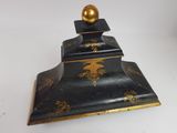 an image of a black and gold box with a golden ball on top