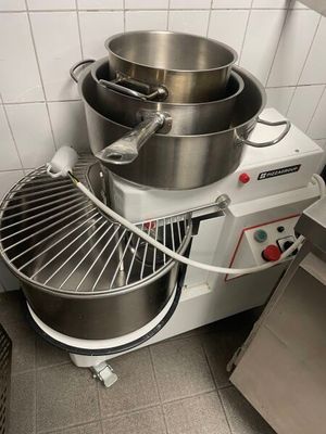 un grand saladier en métal et un grand batteur électrique en métal dans une cuisine