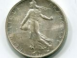 une vieille pièce de monnaie sur laquelle figure une femme marchant sur un fond blanc