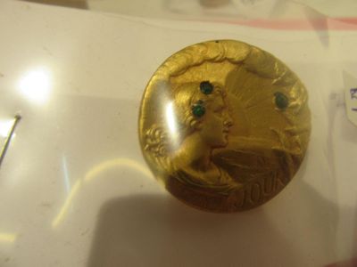 a gold coin with a face on it in a glass case