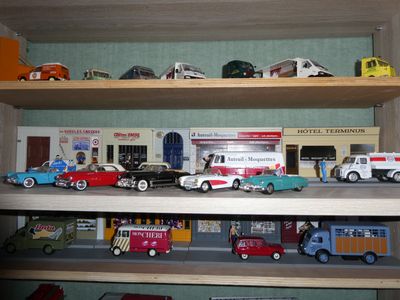 many toy cars and trucks on a shelf in a room