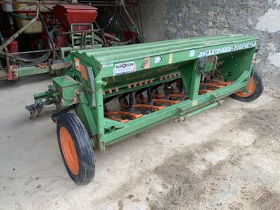 un tracteur vert aux roues orange garé dans un garage