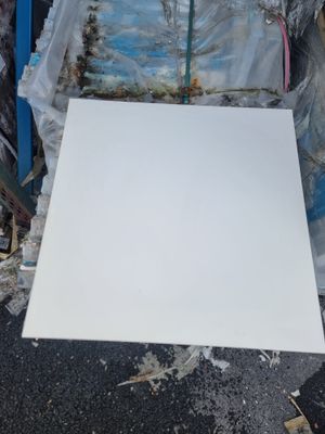 un morceau de papier blanc par terre, à côté d'un tas de plastique
