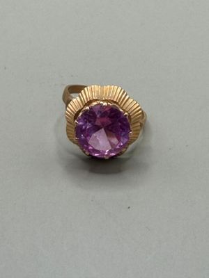 a close up of a ring with a purple stone in it