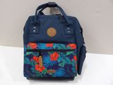 blue and red backpack with tropical print on it sitting on a white surface
