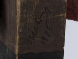 a statue of a man holding a hammer on top of a piece of wood