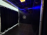 une salle de bains avec un rideau de douche noir et une lumière bleue