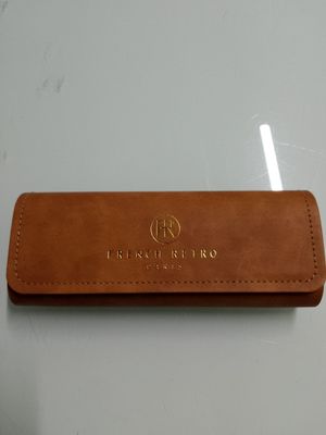 a close up of a brown leather pen case on a table