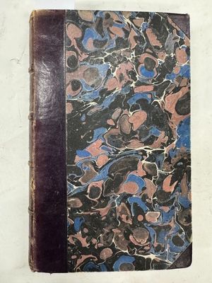 un vieux livre posé sur une table recouverte de marbre