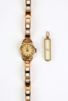 une image représentant une montre en or et un porte-clés posés sur une surface blanche