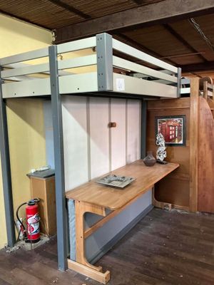 un lit superposé avec un bureau en dessous, dans une chambre