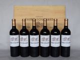 six bouteilles de vin rouge devant une caisse en bois
