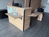 un bureau en bois sur lequel est posé un ordinateur, dans une pièce