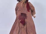 a doll that is wearing a hat and a dress