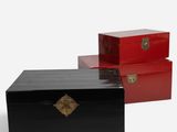 deux boîtes noires et rouges posées l'une à côté de l'autre sur une surface blanche