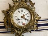 a gold clock on a table with a blue and white striped table cloth