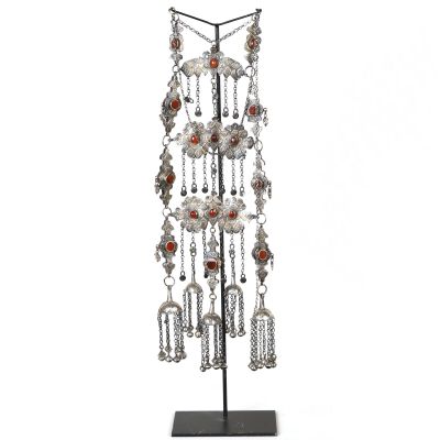 an image of a silver and red necklace on a black stand